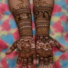 A special design for a baby naming ceremony, with the names "AARAV" and "ANSHIKA" written on the arms. The palms feature a cradle and other cute baby motifs.