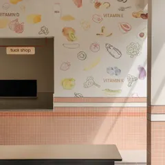 A close-up of the "tuck shop" area, where wall graphics illustrate different vitamins and the foods they can be found in. This simple visual guide makes nutrition science accessible and fun for kids.
