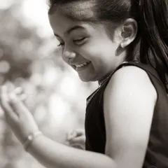 A candid moment of laughter, made even more poignant in black and white. It highlights her genuine expression and the simple beauty of a happy childhood moment.
