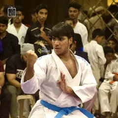 The calm before the storm. A student demonstrates a perfect fighting stance, showing intense focus and readiness before his kumite match begins. This mental preparation is as important as physical training.