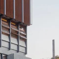 The upper levels of the residence feature operable wooden louvers and vents. These elements allow for natural ventilation and give the inhabitants control over light and privacy, while adding warmth to the concrete structure.