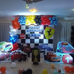 A high-octane Disney Cars theme with a checkered flag backdrop, character cutouts of Lightning McQueen and Mater, and a Ferrari logo for the birthday boy.