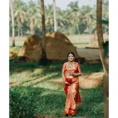 A beautiful portrait of an expecting mother in a traditional silk saree, walking through a rustic Karavali landscape with coconut palms in the background. This style of outdoor maternity photography celebrates our local heritage.