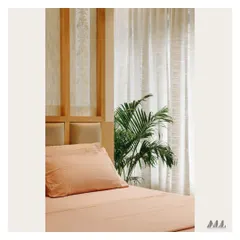 A detail of the bedroom's headboard and bedside area. The design incorporates natural wood and a potted plant, bringing organic elements into the room to enhance its tranquil feel.