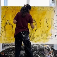 Me in my element, working on a very large-scale sketch directly on the canvas. For big pieces, I often work on the floor or against a large wall in my studio.