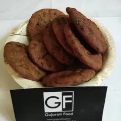 A bowl of my homemade Bajra Vada. These are deep-fried fritters made from pearl millet flour and spices, offering a unique texture and taste that is both crispy and savory.