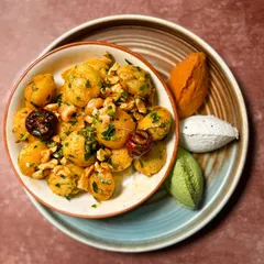 Our Gunpowder Idli is a house favorite and a perfect conversation starter for any event. These mini idlis are tossed in a flavorful spice mix and served with an assortment of chutneys for dipping.