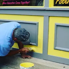 A close-up of detailed brushwork on a commercial storefront. For trim and paneling, I use precise brush techniques to ensure complete coverage and crisp edges.