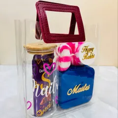 Another angle of the Rakhi hamper for a sister, showing the personalized name 'Maitri' on both the glass tumbler and the blue jewelry box.