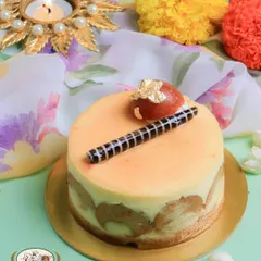 Our Gulab Jamun Mini Cheesecake is an elegant, single-serving dessert perfect for Diwali. It features a creamy cheesecake base with a surprise gulab jamun inside, garnished with a chocolate stick and gold leaf.