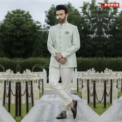 This pastel green Jodhpuri suit offers a unique color choice for festive wear. The subtle geometric print on the jacket, paired with off-white trousers, makes for a stylish and modern ethnic outfit.