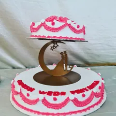 A classic floating-tier wedding cake. This design features traditional white and pink piping and a romantic couple silhouette topper, symbolizing the start of a new journey.