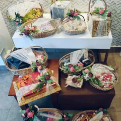 We manage large-scale gifting projects with consistent quality and design. This assortment of coordinated gift baskets and boxes, each adorned with matching floral arrangements, demonstrates our ability to cater to the entire wedding party.