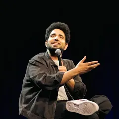 Comedian Samay Raina on stage during his standup special, with his custom "Unfiltered" Nike Air Force 1s prominently featured.