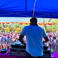 There's nothing like a daytime Holi festival. This is my view from the console, looking out at a massive, colorful crowd dancing under the sun. I love bringing high energy Bollywood and Punjabi bangers to these outdoor events.