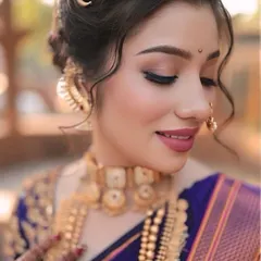 A close-up of this stunning Maharashtrian bride. The soft glam makeup with a defined winged liner and pink lips perfectly complements her royal blue saree and traditional gold jewellery.