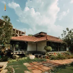 An exterior view of the center, showing its unique architecture and integration with the surrounding nature. It is a true sanctuary in the heart of Delhi.