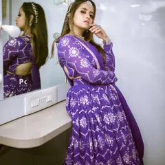 This vibrant purple lehenga with silver floral motifs is a modern and stylish choice for an evening event like a sangeet or reception.