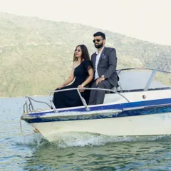 An adventurous couple enjoying a speedboat ride on Tehri Lake. This shot captures the thrill and joy of starting a new life journey together, set against a stunning natural backdrop.