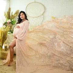 Shimmer and shine in this sequined gown with a flowing train. This portrait, taken in our boho-chic studio, captures a moment of glamour and elegance, using the light to make the fabric sparkle.