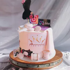 A cake designed for a fashion designer! This creation features a mannequin, logos for Instagram and Meta, a laptop, and edible sewing supplies like thread spools and buttons.