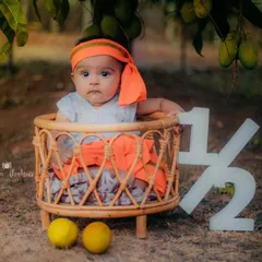 Celebrating six months with a unique mango-themed outdoor shoot. The natural setting adds a beautiful touch to these milestone photos.