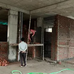 Workers on scaffolding during the bricklaying process. Our site supervision ensures that every element, from the structural columns to the infill walls, is executed according to our precise architectural plans.