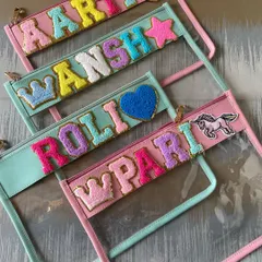 Stash your stuff in style with our trendy clear travel pouches. We use colorful, sparkly chenille letters to spell out your name, making it a fun and practical accessory.