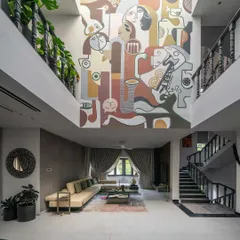 A full view of the 'House of the Rising Sun' living area, where the massive mural is illuminated by a skylight. The artwork's palette was designed to complement the changing natural light throughout the day, making the home feel alive.