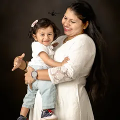A mother's love shines in this beautiful portrait. The genuine smile and warm embrace between mother and child is a moment to be treasured forever.
