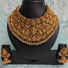 A close-up of an incredibly intricate antique choker. This statement piece is filled with detailed carvings of gods, goddesses, and peacocks, making it a true work of art for your special day.