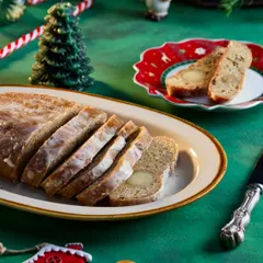 This image showcases a sliced Stollen bread, a traditional German Christmas treat, for Marriott's festive gifting range. The green background and Christmas-themed props like the candle and candy cane add to the holiday cheer.