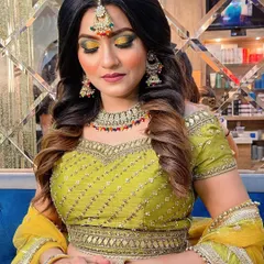 We love creating bold and vibrant looks for our clients. This photo showcases a stunning Haldi or Mehendi look, featuring a dramatic yellow and green smokey eye, contoured cheeks, and a hairstyle that complements the entire festive outfit.
