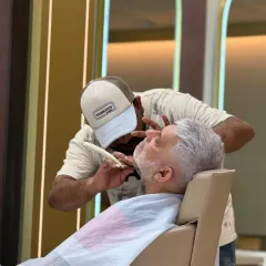 A perfect beard is all about the details. Here, our expert stylist is performing a precision beard shave, carefully defining the lines for a sharp and immaculate finish.