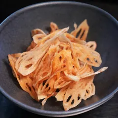 We pair our slow-braised lamb shank with crisp lotus stem chips. This adds a playful crunch and textural contrast to the tender, fall-off-the-bone meat.
