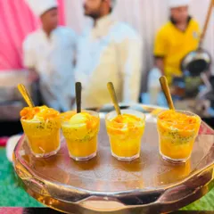 A close-up of our refreshing Mango Falooda, layered with mango pulp, ice cream, and basil seeds. It's a classic Indian dessert that we serve in individual glasses for easy enjoyment.
