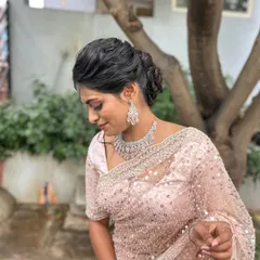 The client looking elegant with her textured updo, paired with a sparkling saree and diamond jewellery.