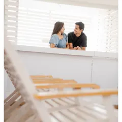 A candid shot of the couple sharing a conversation. Using foreground elements like the chairs adds depth and a sense of place to the photograph.