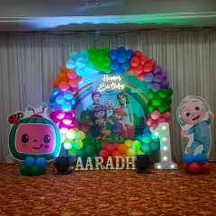 For a child's first birthday, I created this vibrant Cocomelon themed stage decoration. It features a colorful balloon arch, a personalized backdrop with the birthday boy's name, character cutouts, and a light-up number '1' to make the celebration extra special.