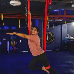 Aerial yoga is for everyone, regardless of age or experience. Here, a client gracefully holds a supported pose, demonstrating the balance and poise you can develop in my classes.