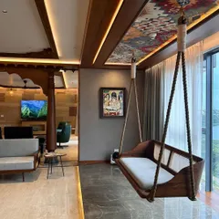 A standout feature in the Embassy Lake Terraces apartment is this traditional Indian oonjal, or swing. We suspended it by the window, creating a perfect spot for relaxation with a view. The ceiling panel above features a vibrant textile pattern, adding a unique decorative touch.