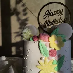The sunlight hitting this floral birthday cake is just beautiful. I used buttercream to create the flowers and leaves, and added macarons for a modern touch. It's a simple but elegant design.
