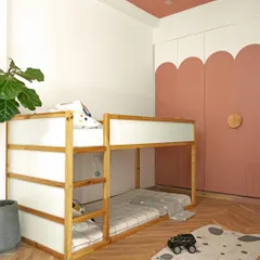 This space-efficient bunk bed is designed with clean lines in natural wood and white, creating a light and airy feel. The scalloped, blush-toned wardrobe doors add a touch of softness and whimsy, concealing ample storage.