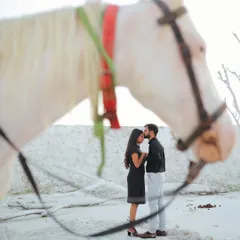 A unique and artistic shot using a horse to frame the couple's intimate moment. This adds a touch of fairytale romance and creates a memorable, story-driven image.