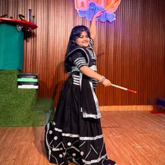 This young dancer strikes a perfect pose, showcasing her beautiful black and silver ghagra choli. Her smile and confident stance capture the true spirit of our Garba classes.
