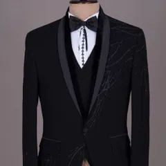 A black tuxedo with unique, asymmetrical sequin work. This is a modern and artistic take on formal wear.