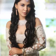 A stunning look from a professional photoshoot. This modern bridal style features soft waves, a diamond-dusted makeup look, and an off-shoulder lace blouse.