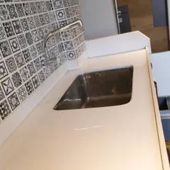 The details matter. This image shows a high-quality Corian countertop with an integrated sink, set against a classic black and white patterned tile dado, adding a touch of timeless charm.