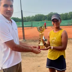 Manshi Singh accepts her trophy after winning the Women's title at a UTR tournament. Her victory is a result of her dedication and the will to prepare to win.