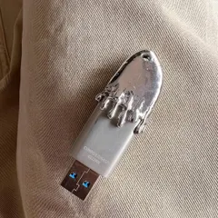 A close-up of the custom silver-capped USB drive. This piece shows how the Frostbite aesthetic can be applied to more than just grillz, turning an everyday object into a unique accessory.